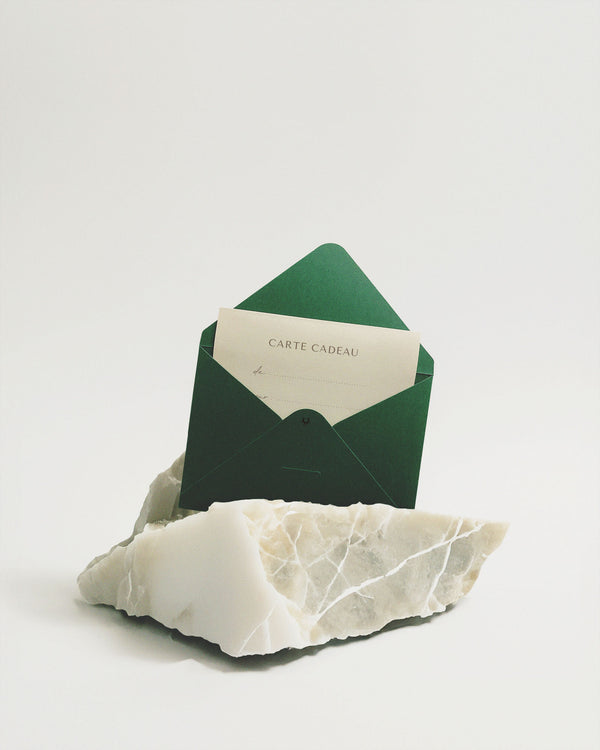 Carte cadeau TAMMY & BENJAMIN 150€, enveloppe verte posée sur un bloc de marbre