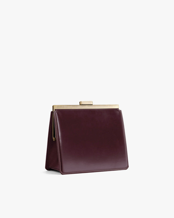 Sac JEANNE Mahogany vu de côté, posé, fermoir métallique doré fermé, sans bandoulière visible